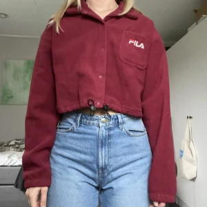 Fila fleece - En croppad Fila fleece i mörkröd. Knappt använd så i nyskick! Nypris: 595kr. Köpt för flera år sen🦥