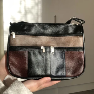 Vintage väska - Unik vintage väska. Nyskick! Har massa fickor på framsidan, en innanför och en baksidan. Justerbar band. Frakt tillkommer. Skriv vid frågor 🦋