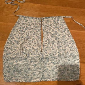Ginatricot halterneck  - Köpte men kunde aldrig använda den då den ej satt bra eller passa mig så helt ny Linnet är vitt med små blåa blommor och är öppen i ryggen och man knyter den runt halsen 
