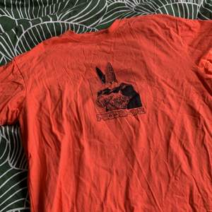 En t-shirt i orange färg, storlek Xs med dragonball tema. Även i den minsta storleken är den rätt lös då den är menade så! 