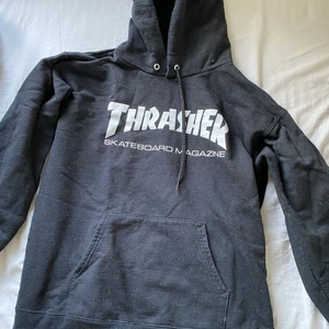 Thrasher hoodie (Frakt betalas av köparen)  - Svart äkta Thrasher hoodie i storlek 34-36. Hoodien är lite oversized så funkar även om man har större storlek. Hoodien har jätte små hål på baksidan som knappt syns. (Se 3:de bild). Annars i bra skick och säljer eftersom ej använder hoodien längre. 