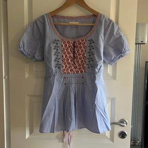 Odd Molly kort ärm blus - Fin kort ärm blus från Odd Molly, strl 4, ljusblå med detaljer fram i röd/vit/beige Köpare står för frakt