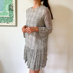 Blommig Klänning Från Ganni med Volanger S - Säljer en jättefin klänning från Ganni som jag burit mycket. Det syns dock inte att den är använd bortsett från en liten lagning i halskanten i ryggen. Blommorna är svarta, gula, lila och gröna. 100% viskos. Har en inbyggd underklänning. 