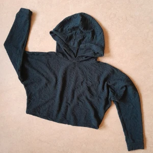 Croppad luvtröja - En svart tröja med luva i croppad modell, storlek S från Nelly trend. Tyget är lite strukturerat och den är enkel men förvånansvärt snygg, har fått många komplimanger med den! Den har börjat bli liiite nopprig men absolut inte så det stör. 35 kr + frakt ☆