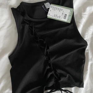 Svart topp - Svart topp med knytning stvärs över aldrig använd💞 