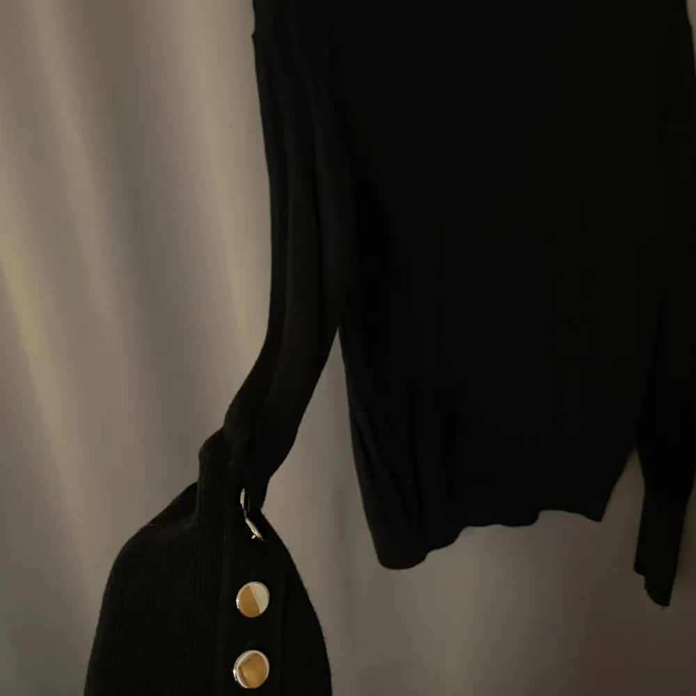 En långärmad tröja med krage och detaljer på armar . Tröjor & Koftor.