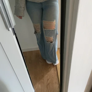 Jeans - Blåa jeans med hål vid knäna använd fåtal gånger och är bra skick