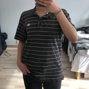 Adidas t-shirt  - Säljer den här svarta adidas tröjan med gul beiga ränder(lite använd)