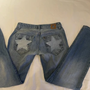 Lågmidjade jeans - Så snygga lågmidjade jeans med stjärnor på bakfickorna. Waist storlek 32  skulle säga att de passar 36-38