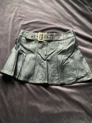 Kjol - Säljer en använd kjol från Bikbok. Den är köpt 2004 och har en liten reva vid sömmen på insidan men ingenting som syns utanpå och går lätt att fixa.   Gjord av 100% läder och är använd.   Den sitter fint, kom privat för mer bilder.   Nypris 1000kr