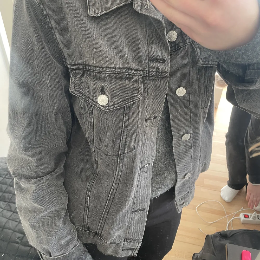 En svart/grå jeans jacka ifrån Gina tricot . Jackor.