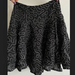 Kjol - Söt festlig kjol i coolt mönster. Säljer pga att jar inte fått användning för den. 