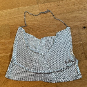 Topp H&M  - Supercool silvrig topp från H&M, gör sig ej rättvis på bild. Öppen rygg med endast en kedja bak och i nacken. Köparen står för frakten! ✨