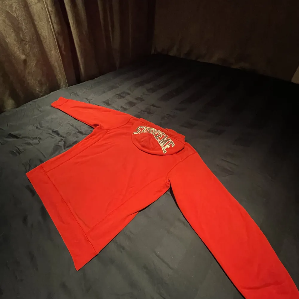 En röd supreme hoodie med SUPREME textat med paljetter på luvan, stadigt material i gott skick.. Hoodies.