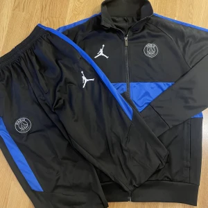 PSG tracksuit - Blå svart Paris Saint Germain Dri-Fit dress i storlek L men passar M också. Dressen är i riktigt bra skick förutom att det är två riktigt små hål på byxan som knappt syns.  Fraktas och möts, öppen för bud och kontakta ifall du är intresserad!