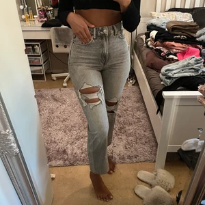 Ljus gråa jeans - Ett par ljusgråa jeans med hål, köpt från H&M. De är högmidjade och inte alls stela i materialet. Byxorna är inte så ljusa bakifrån, det är pga ljuset