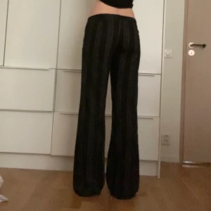 Randiga kostymbyxor - Ett par vida, lågmidjade, pinnstripe byxor.