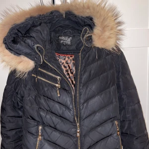 Hollies jacka chantel - Äkta hollies jacka i modellen chantel. Äkta päls, svart färg på jackan. Storlek 38.  Dragkedjan funkar inte bra, kan vara strulig.