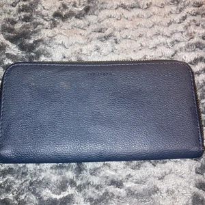 Plånbok  - Den är mrökblå och den är stor om man vill gå ut med en stor plånbok så passar dem här dig. Andvänd men som ny.