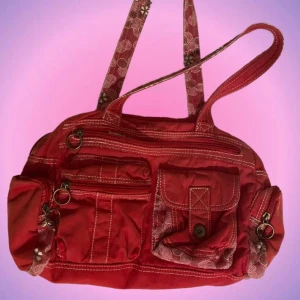 Röd minibag - Så söt röd mini bag med lite mönster här o där! Den har flera olika fack på både utsida och insida😍 På framsidan finns ett litet hål men inget jag tycker stör! Priset kan diskuteras! Hör av er vid intresse❤️