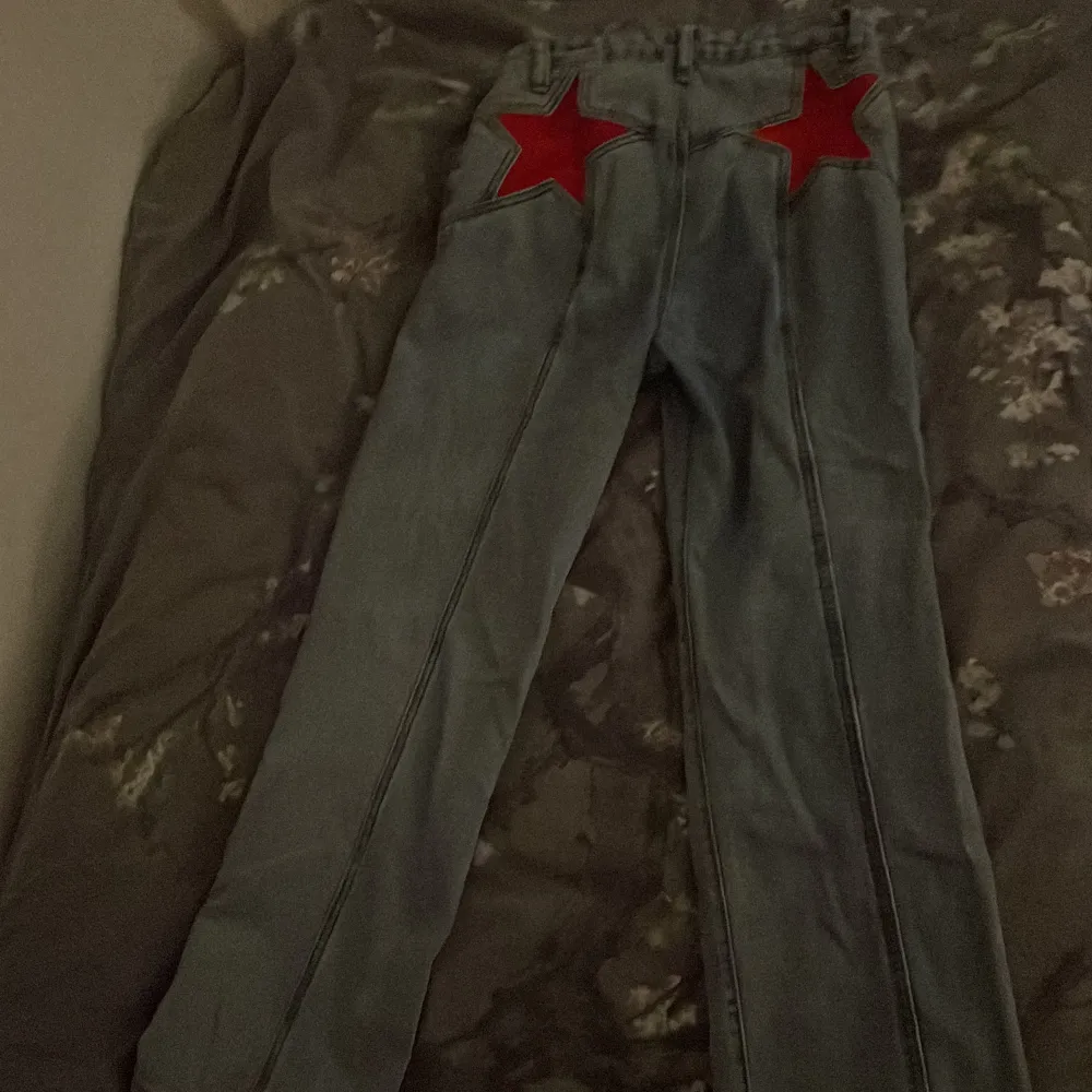 Ett par blå/grå högmidjade jeans med röda stjärnor där bak är en s men tycker detta nästan är som en m/l . Jeans & Byxor.