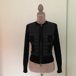 Moncler dunjacka  - Vävd i ullkonstruktion med fjäderdun framtill, stickat från ull till en slimmad siluett. Denna Moncler-jacka har fyra vävda patchfickor för en strukturerad finish. QR kod finns på insidan! 