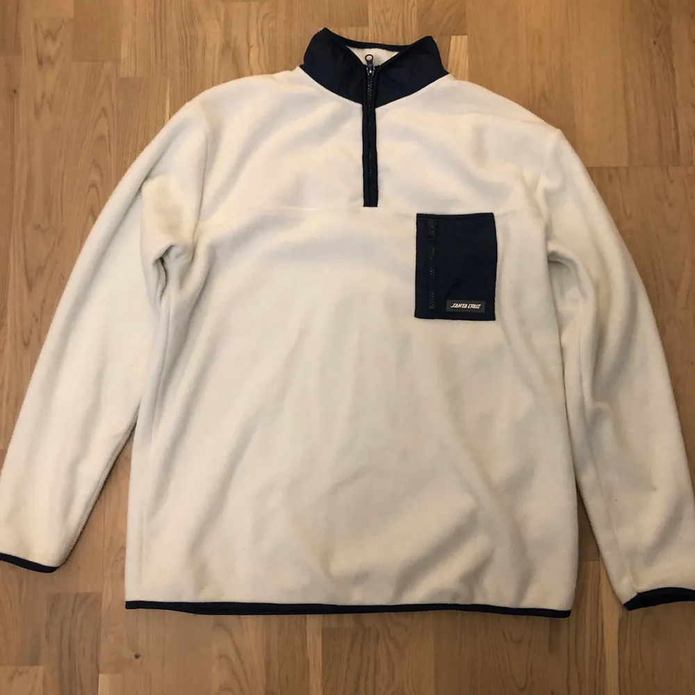 Snygg vit med blå detaljer fleece tröja med storlek M, kan passa för smaller fit L. Har en ytterst liten fläck som inte syns när man har på den.. Neuletakit & Villapaidat.