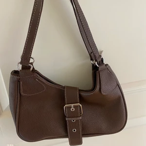 Väska - Jättefin brun väska. Aldrig använd. Ser lite sne ut pga hur bilden tagits men är inte det egentligen. *Köparen står för frakt.