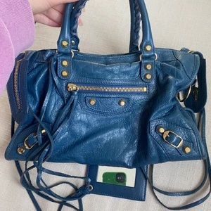 Balenciaga City Bag - Intressekoll på min balenciaga city bag i blå läder med guld detaljer. Ca 30x18. Långt band kommer med. Använd men så gott som ny i skicket. Givetvis äkta och det finns orderbekräftelse från balenciaga.com.       Köpt för 16000. Direktpris 10000. 
