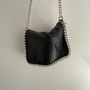 Svart väska - Säljer min väska från tiamo! Bra storlek och bra skick förutom de man kan se på bild två!