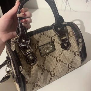 Gussaci väska - Köpte denhär secondhand i sommras för jag tyckte den liknade nåt från en bratz film. Men inte min stil. Tror det är Gussaci kan ingenting om det märket men det liknar det. Skriv till mig vad ni tycker är ett rimligt pris!!!!