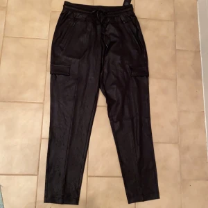 Tunna Skinn byxor  - Jätte fina byxor med snörning och fickor som stängs med dragkedjor. Är av tunt material, liknande vid mjukis/träning byxor. Aldrig använda. Från märket comma, !!
