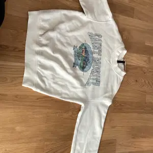 En vit sweatshirt från hm med tryck på framsidan 