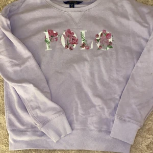Polo tröja - Mysig och bekväm Polo Ralph Lauren tröja. Jätte snyggt med blommorna som klär Polo loggan! Vacker färg!