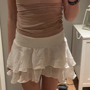 Vit volangkjol  - En vit volang kjol som passar till det mesta i garderoben !! Den är i storlek S men väldigt stretchig. Midjan är lite längre men går lätt att vika ner som på bild 1 💘 Går att mötas upp i sthlm området, säljer kjolen för 75kr 🫶