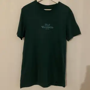 Mörk grön T-shirt från HUF  Använd fåtal gånger så i toppen skick   Storlek herr small 