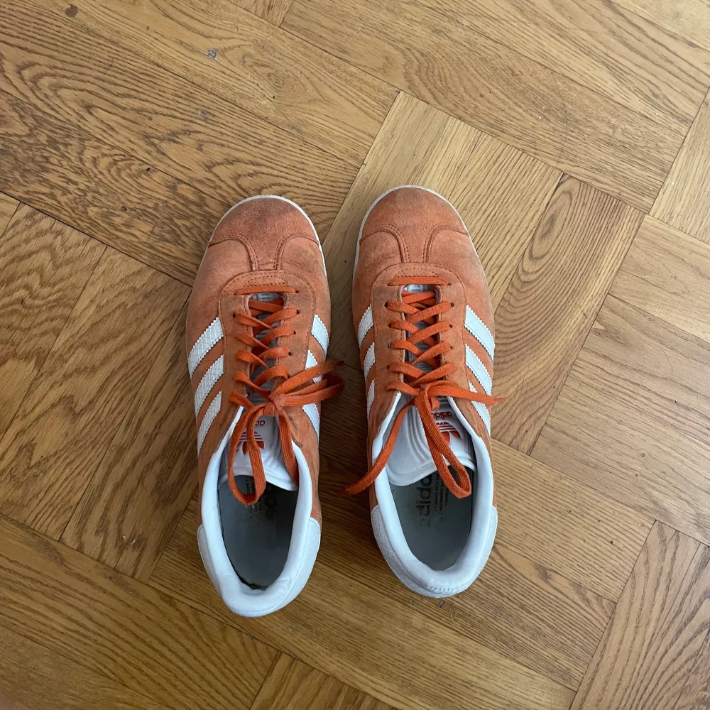 Adidas gazelle-skor i orange. Använda men ändå i bra skick och har många år kvar! . Skor.