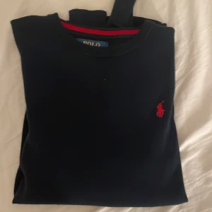 Polo tröja  - Säljer denna marinblåa Polo Ralph Lauren tröjan pga att den blivit för liten. Inte använd mycket och väldigt bra skick! Inga hål. 💞 Sista bilden är tagen me blixt!!!