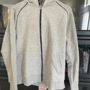 Kofta - En grå kofta i storlek L. Den är i ganska bra skick men den är använd mycket. 