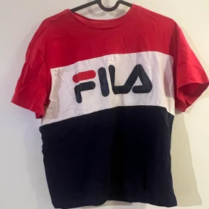 Fila T-shirt  - Randig T-shirt från fila, strecken är i rött, vitt och mörkblått. Fint skick.