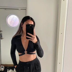 Svart top - En svart top där man kan knyta runt vid midjan. Storlek Xs/s 