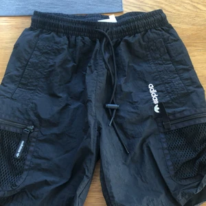 Adidas Shorts - Svarta adidas shorts. Cargo actiga i stilen men mer tränings shorts. Fyra fickor totalt (se bild)  Dem är inte oversize Köpte dem för 500kr, glömde bort dem och har bara använt dem en gång