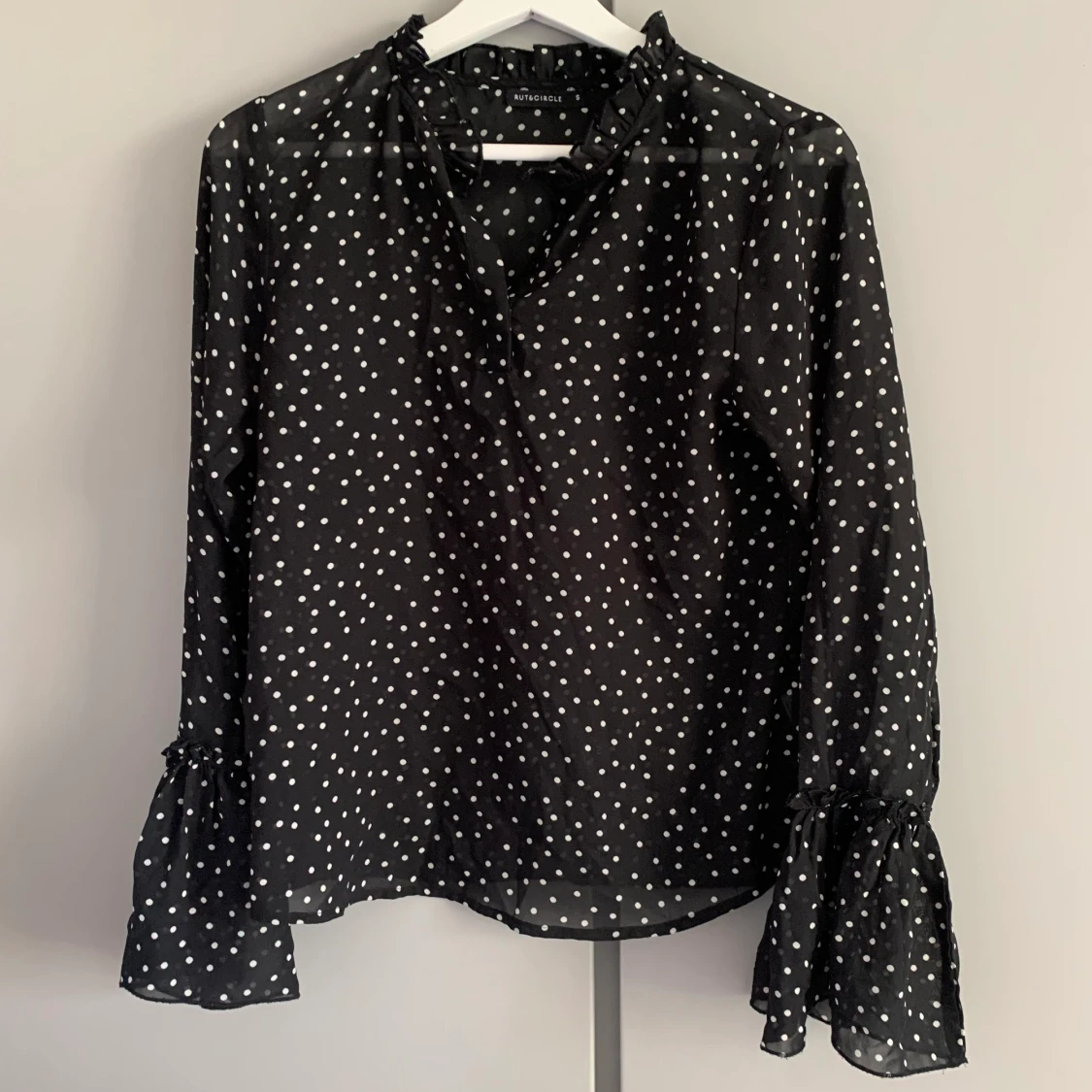 Prickig blus i svart och vitt med volang