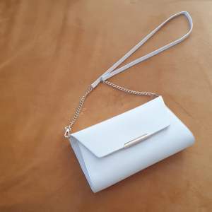 White clutch with golden details. 100% polyester.