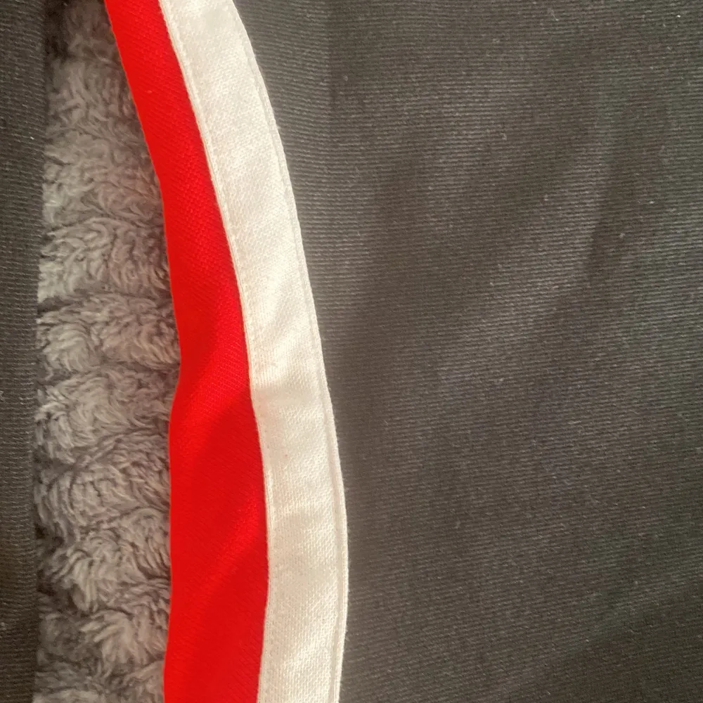En svart takt klänning med röd och vitt sträck på sidorna kommer från H&M i storlek 32. Använd en gång 💝. Klänningar.