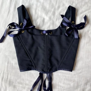 Mörkblå korsett topp helt ny!  - Helt ny korsett topp med guld detaljer och satinband sydd av mig, storlek XS-S, justerbara axelband och baksida! Mått: Byst: ca 75-82cm Underbyst/midja: ca 60-68cm Längd: ca 20cm 