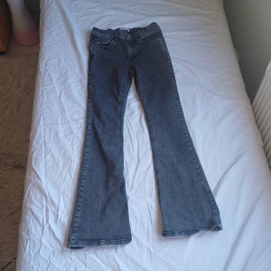 Grå bootcut jeans från Perfect Jeans - Snygga  bootcut jeans från Perfect Jeans ginatricot. De har en klassisk femficksdesign och en bekväm passform. Perfekta för en avslappnad stil med en touch av retro. Mid-low waist. Storlek 38 på lappen men mer som en 36.