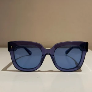 Blå solglasögon från Chimi - Snygga blå solglasögon från Chimi med en fyrkantig form och transparent båge. De har en modern look och passar perfekt för soliga dagar. Modellen heter ACAI storlek 08  har en stilren design. Endast testade, säljs inte längre 