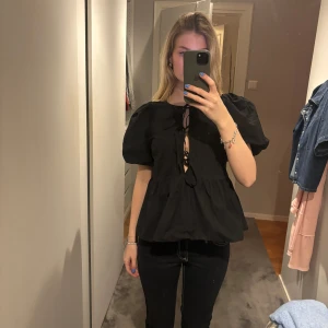 Svart blus med knytning - Säljer en svart blus med puffiga korta ärmar och knytning framtill. Endast använd fåtal gånger🩷🩷