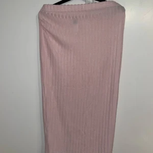 Rosa ribbad kjol från Shein - Säljer en söt rosa ribbad kjol från Shein. Kjolen har en enkel och stilren design som passar perfekt för olika tillfällen. Den är gjord i ett mjukt och bekvämt material.